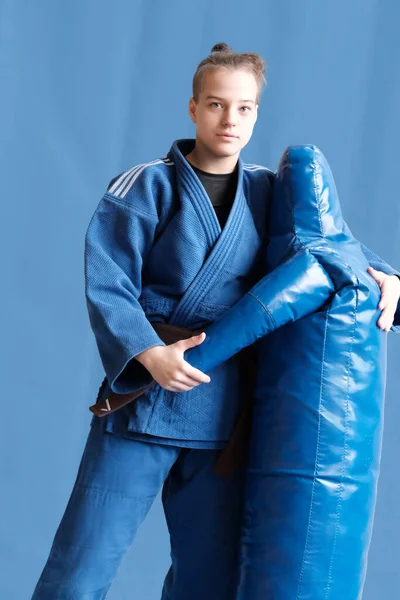 柔道女孩与棕色带 一名柔道少年战士身着蓝色和服 背景平平 日本武术 武术训练的过程 健康的生活方式 体育概念 — 图库照片