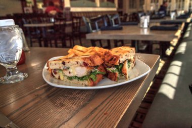 Kızarmış yaban mersinli ekmek ve patates kızartması arasında tavuklu sandviç..