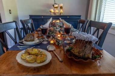 Bir kuzu pirzolası, buharda pişirilmiş enginar, patates ve kemik üstünde Çin tabağı ve mumlar..