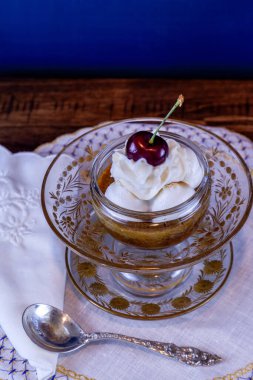 Altın işlemeli antika bir cama işlenmiş karamelli sufle ve gümüş çatal bıçak takımı..