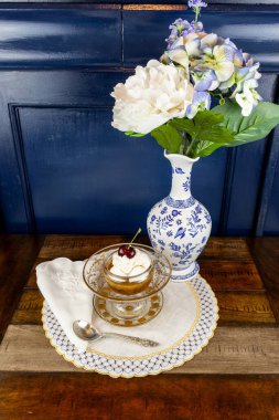 Altın işlemeli antika bir cama işlenmiş karamelli sufle ve gümüş çatal bıçak takımı..