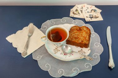 Öğleden sonra çayı ve havuçlu kek, kağıt oynarken atıştırmalık bir tabakta..