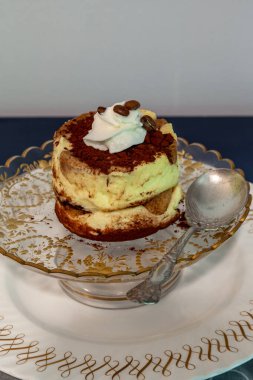 Krem şantili tiramisu ve altın işlemeli kahve çekirdekleri..