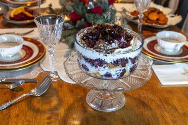 Black Forest Trifle Cake with cherries, whipped cream and shaved chocolate soaked in brandy on a holiday table. clipart