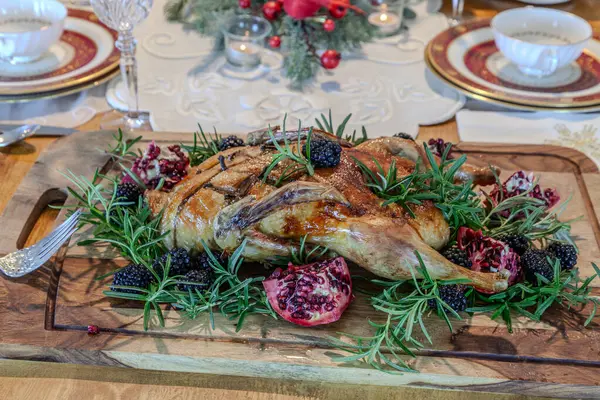 Böğürtlenli biberiye ve kesme tahtasındaki nar meyveli Noel hindisi..