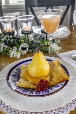 Armut şampanyada haşlanır, zencefil ve tutkulu meyve suyu ve porselen üzerinde puf böreği..