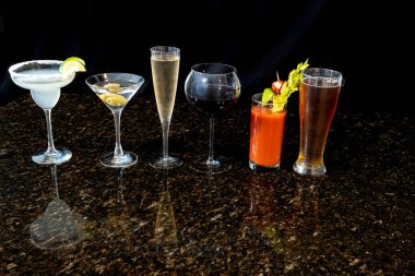 Büyük bir kokteyl grubu margarita, martini, şampanya, şarap, bira, Bloody Mary ve siyah bir arka planda viski..