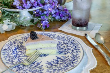Böğürtlenli ve böğürtlenli Chantilly Pastası. Süslü bir gurme masasında yaban mersinli krema..