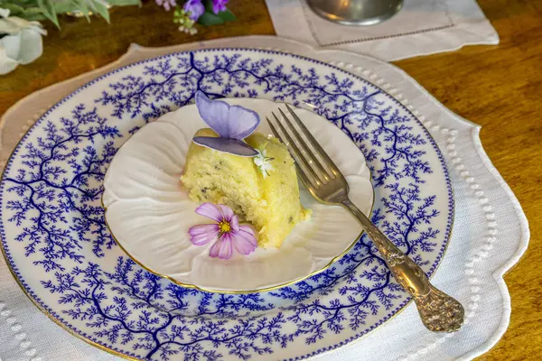 Eflatun ve limonlu kek, şekerli gofret kelebekleri ve mor masa düzeninde garnitür için çiçek..