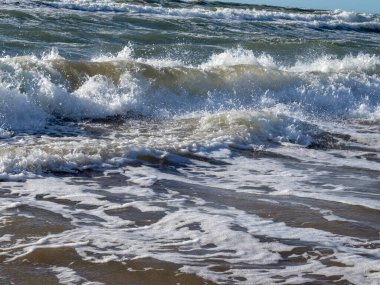İsrail 'in Akdeniz kıyısındaki kumda dalgalar ve köpük.