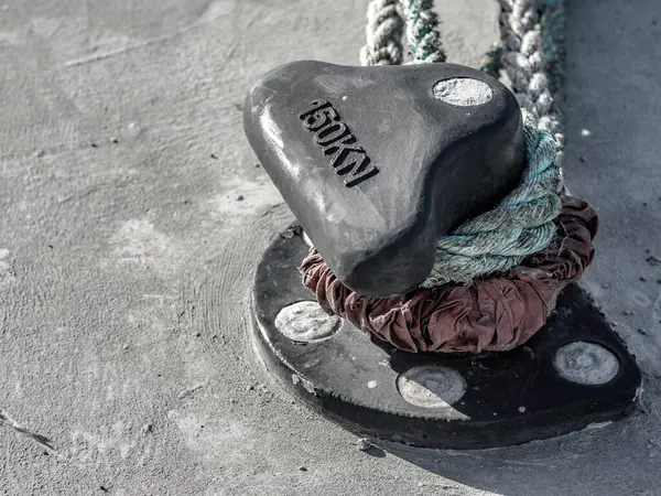 Taşın üzerinde kırmızı kalbi olan siyah metal bir çapa.