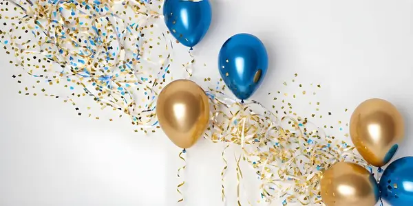 stock image A vibrant arrangement of blue and gold balloons is set against a light background, accompanied by scattered confetti, creating a festive atmosphere ideal for celebrations.