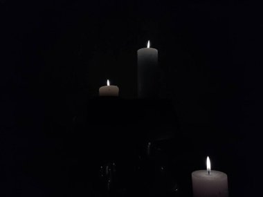 Gece karanlığında yanan beyaz mumlar.