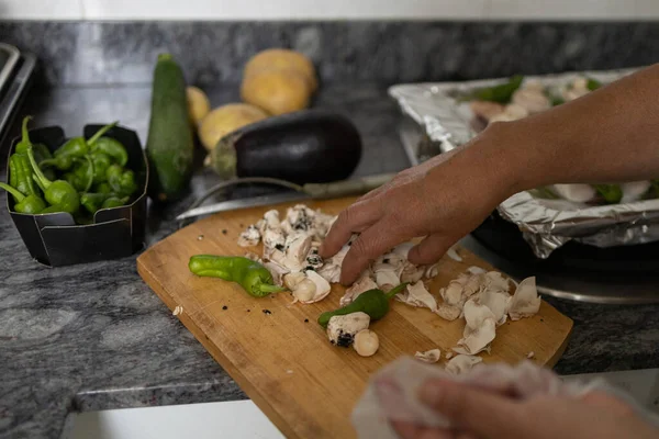 woman cooking in the home kitchen with organic and biological vegetables cut on a wooden board. vegan and vegetarian concept.