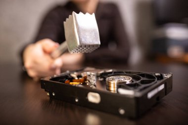 Bir ofis çalışanı çekiçle sabit diski yok ediyor.