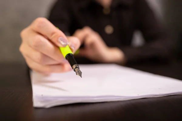 A businesswoman holds a calligraphy pen in her hand