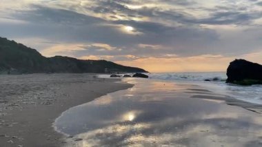 Sahilde gün batımında dalgalar kıyıya vuruyor. Yüksek kaliteli FullHD görüntüler