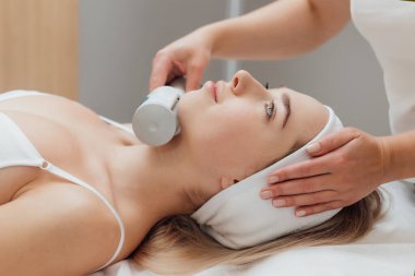 Kadın güzellik kliniğinde yüz ve vücut bakımı görüyor.