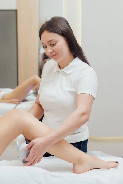 Woman getting body sculpting treatment at beauty clinic