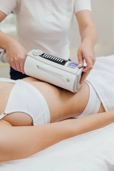 Woman getting body sculpting treatment at beauty clinic