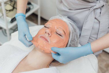 Kadın güzellik kliniğinde yüz ve vücut bakımı görüyor.