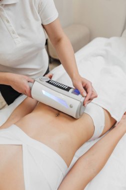 Kadın güzellik kliniğinde yüz ve vücut bakımı görüyor.