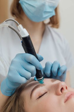 Kadın güzellik kliniğinde yüz ve vücut bakımı görüyor.