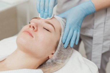 Kadın güzellik kliniğinde yüz ve vücut bakımı görüyor.