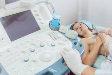 Klinikte ultrason taraması yaptıran genç bir kadın.