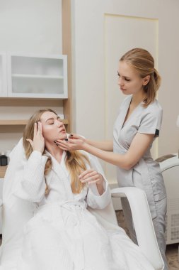 Kadın güzellik kliniğinde yüz ve vücut bakımı görüyor.