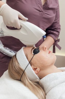 Kadın güzellik kliniğinde yüz ve vücut bakımı görüyor.