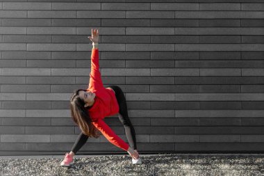 Spor giyiminde kadın modeli dışarıda egzersiz yapıyor..