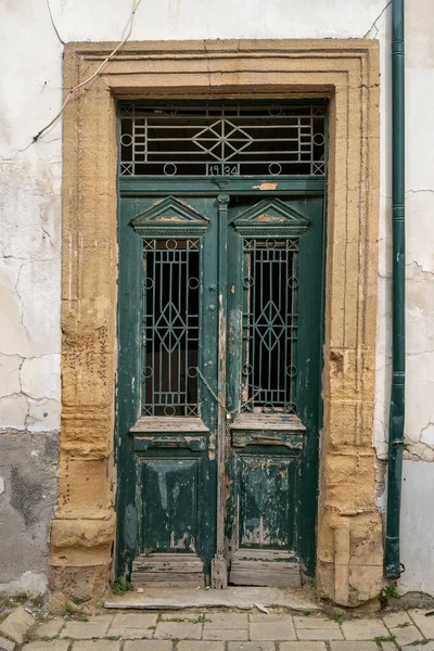 stock image An old house entrance from 1934 with a double-winged front door made of very weathered wood.