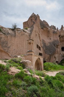 Kapadokya 'nın manzarasında muhtemelen eski bir kilise olan taştan bir kemer var. Yumuşak kayaya oyulmuş. Eritilmiş oluşumlar ve mağara açıkları bölgenin tarihini gösteriyor.