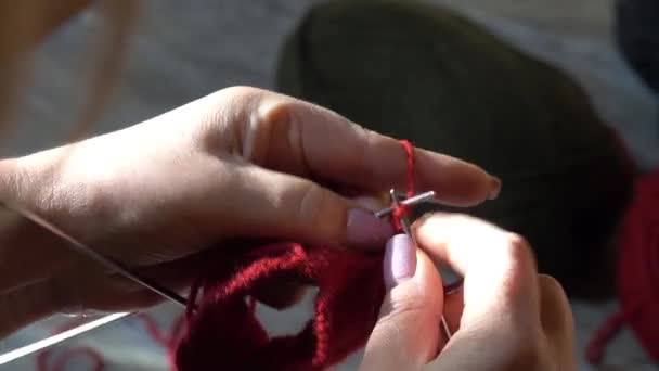 女人用针头和红色的纱线编织袜子 双手合拢 — 图库视频影像