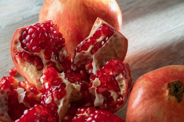 İki taze nar ve gri ahşap bir masada bir kesik. Yakın plan.