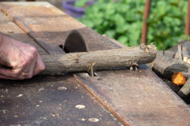 Endüstriyel elektrikli elektrikli elektrikli testere ile odun kesen bir işçinin elleri. Kış için odun topluyorum, kereste fabrikası. Daire testereli odun testeresi