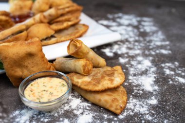 Gri arka planda çeşitli Asya hamur işleri var.