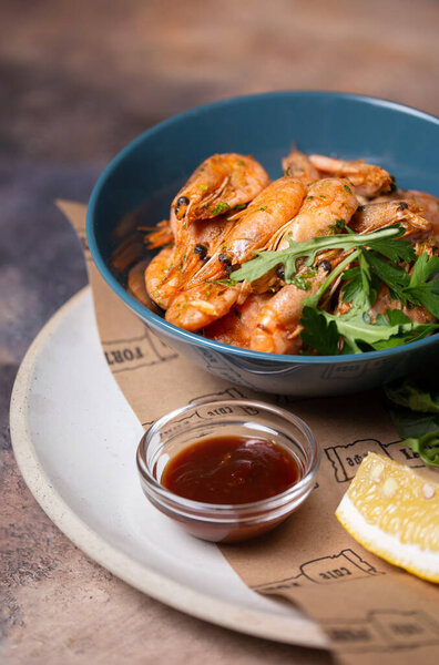 shrimp with lemon and herbs in a blue plate.