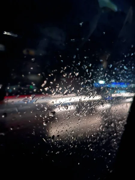 Jasne Światła Nocnego Miasta Przez Szkło Krople Deszczu Abstrakcyjne Tło — Zdjęcie stockowe