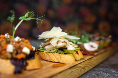 Ahşap bir tahtanın üzerinde değişik aromalı bruschetta..