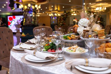 Beyaz peçeteler, bir restoranda tabakta güzelce katlanmış. Restoran içi..