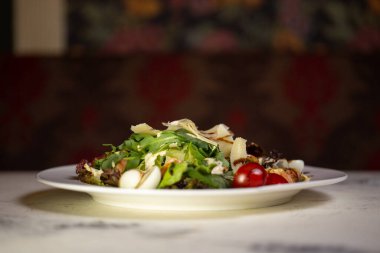 Restoranda karides, domates, peynir ve otlu salata..