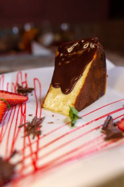 a piece of sponge cake with chocolate and berries on a white plate.