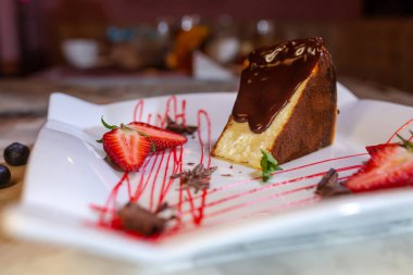 a piece of sponge cake with chocolate and berries on a white plate.
