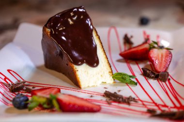 sponge cake with chocolate and berries on a plate in a cafe.