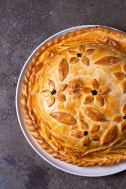 Doldurulmuş sıcak ev yapımı tavuklu turtanın üst görüntüsü. Masada pasta var..
