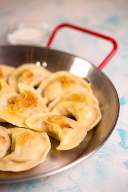 Patatesli börek ve kızarmış tavada ekşi krema..