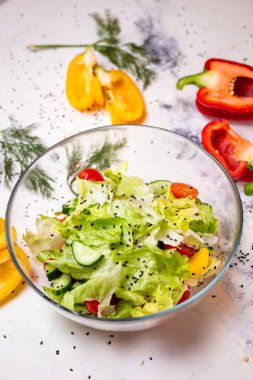 Vejetaryen salatası, domatesli susam tohumu ve cam bardakta salatalık.