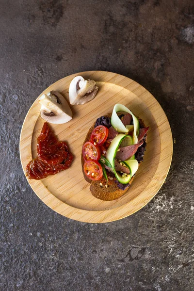 Zbliżenie Czarnego Chleba Bruschetta Pomidorem Ogórkiem Drewnianym Talerzu — Zdjęcie stockowe